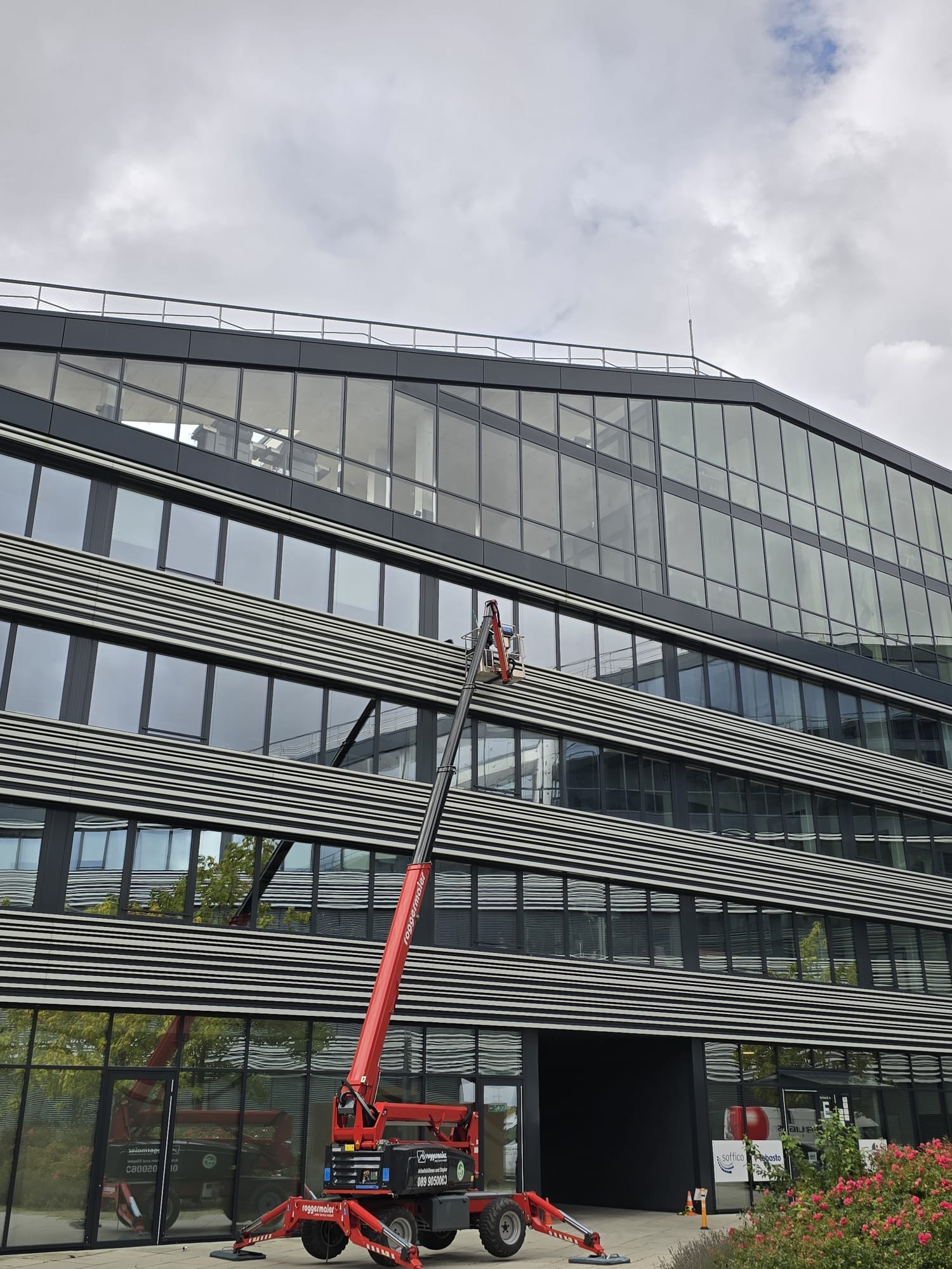 Fassadenarbeiten an einem mehrgeschossigen Gewerbegebäude mit Hebebühne