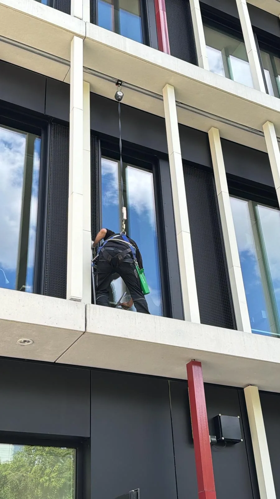 Fachkraft bei der professionellen Glasreinigung an einer modernen Fassade